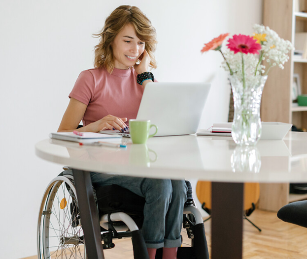 jeune femme en fauteuil travaillant sur ordinateur